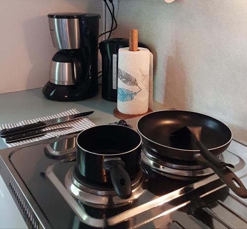 two pots and pans sitting on top of a stove at Apartment Lintu in Mikkeli