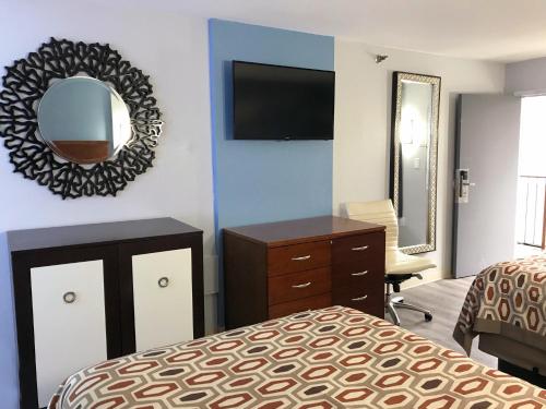 a bedroom with a bed and a mirror and a dresser at Americas Best Value Inn - Decatur in Decatur