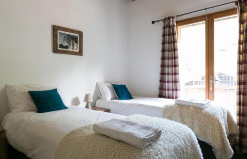 two beds in a room with a window at Chalet Marmotte 1 in Morzine