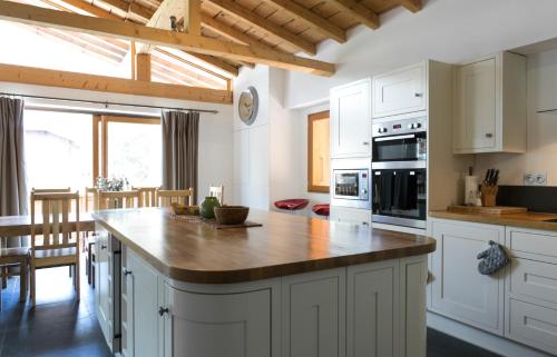 a kitchen with white cabinets and a wooden counter top at Chalet Marmotte 1 in Morzine