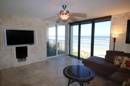 Una sala de estar con un sofá y un televisor de pantalla plana. en Sand Dollar 2-405, en St. Augustine