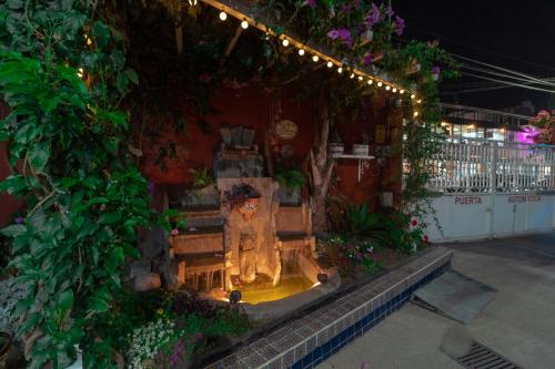 a fountain in a garden with flowers and lights at Hotel Castillo in Texcoco de Mora
