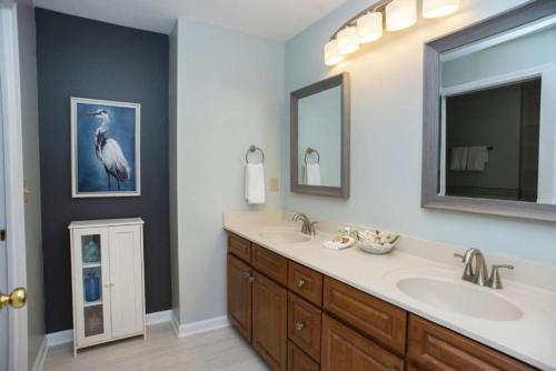 een badkamer met twee wastafels en een grote spiegel bij Seaside at Anastasia C202 in St. Augustine