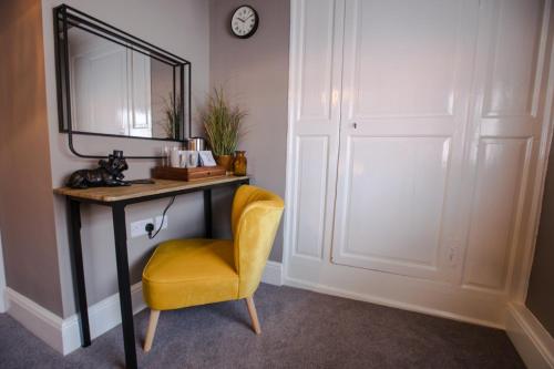 a mirror and a yellow chair in a room at The Wheatsheaf Pub, Kitchen & Rooms in Bingham
