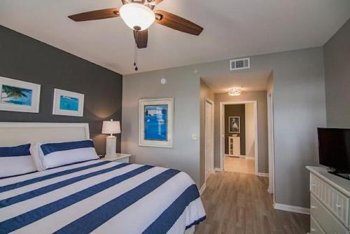 een slaapkamer met een bed en een plafondventilator bij Seaside at Anastasia C202 in St. Augustine