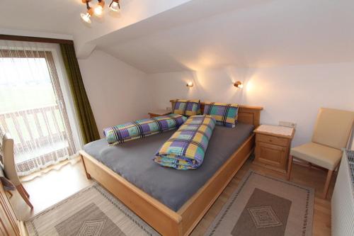 sypialnia z dużym łóżkiem i oknem w obiekcie Gästehaus Hauser w mieście Hainzenberg