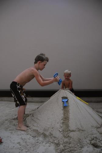 a young boy playing with a sand castle on the beach at Tara Mantra Cha-Am Resort in Cha Am