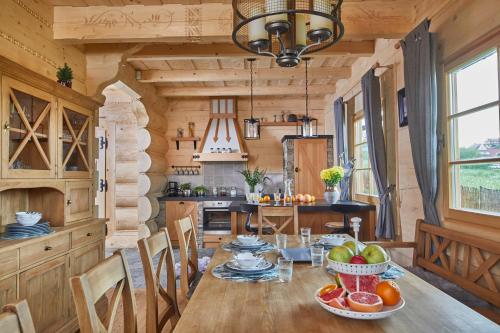 a kitchen and dining room with a wooden table and chairs at Osada Maruszyna in Szaflary
