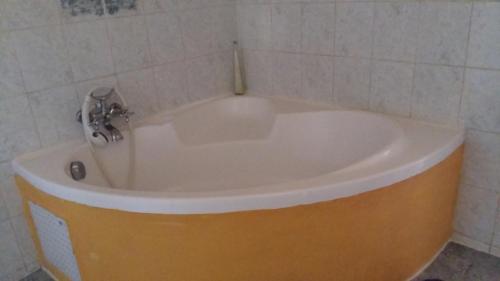a bath tub with a faucet in a bathroom at Gîte MarieJo in Villandraut