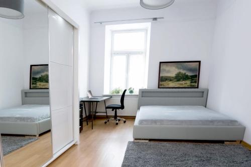 a bedroom with two beds and a desk and a mirror at Apartment - OLD TOWN - Cyrulicza in Lublin