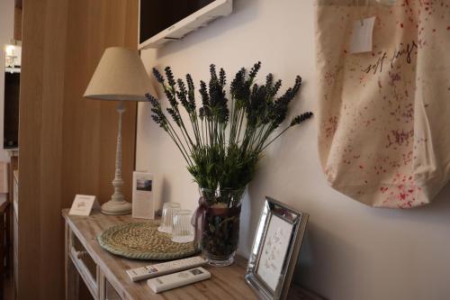 a vase of flowers on a table with a lamp at Hostal Boutique Olvido 22 Adults Only in Peñíscola