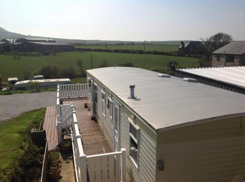 an overhead view of a building with a metal roof at Criw Bach Static Caravan in Bryncroes