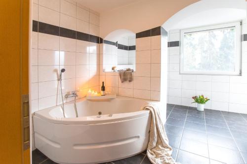 baño con bañera blanca y ventana en Neanderappartement, en Mettmann