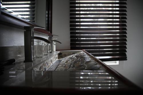 a glass counter top with a sink and a window at Charming Home Near Ski Areas in Rumford