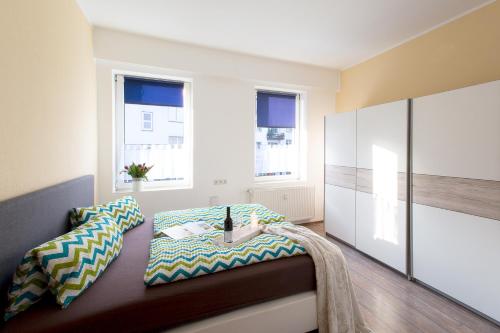 a room with a bed and two windows at Neanderappartement in Mettmann