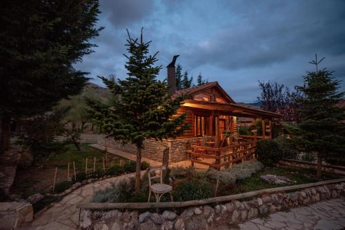 a log cabin with a tree in front of it at Orias Guesthouse & Farm in Kalavrita