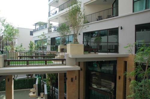 an apartment building with a tree on the balconies at Tara Mantra Cha-Am Resort in Cha Am