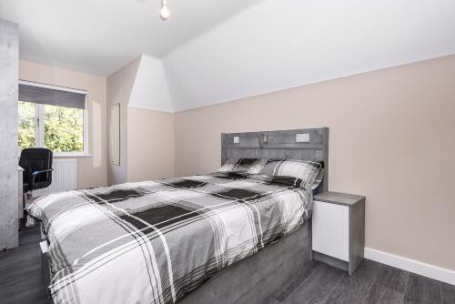 a white bedroom with a large bed and a window at Magna House in Egham