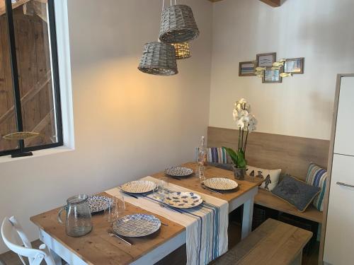 a dining room with a table with dishes on it at Jolie maison au port de l’Ile Tudy in Île-Tudy