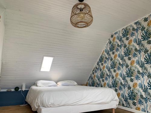 a bedroom with a bed with a blue and white wall at Jolie maison au port de l’Ile Tudy in Île-Tudy