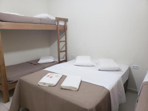 a room with two bunk beds with towels on a table at Hotel Umuarama in Aparecida