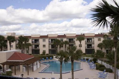 Blick auf ein Hotel mit Pool und Palmen in der Unterkunft Ocean Village Club O36 in St. Augustine