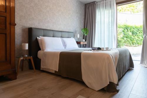 sypialnia z dużym łóżkiem i dużym oknem w obiekcie B&B Villa Fulvia w Albie