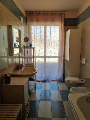 a bathroom with a sink and a toilet and a window at POST A POST in Alba