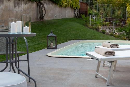 a pool with a table and chairs and a table and towels at B&B Villa Fulvia in Alba