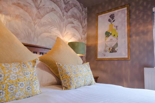 a bedroom with a bed with pillows and a picture on the wall at The Wheatsheaf Pub, Kitchen & Rooms in Bingham