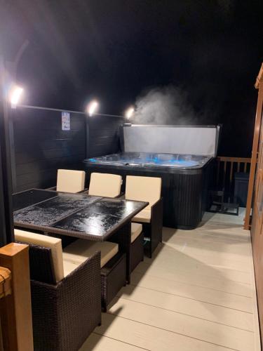 a room with a table and chairs and a hot tub at Moonlight Ridge -2 bedroom lodge with hot tub in Felton
