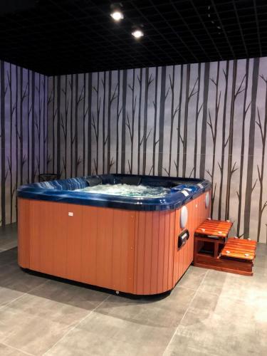 a hot tub in a room with two orange chairs at Hotel Scala d'Oro in Vodice