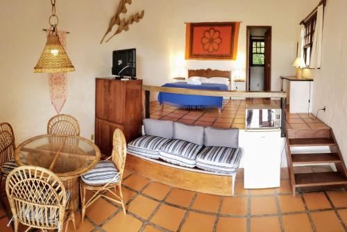 sala de estar con cama, mesa y sillas en Pousada da Lagoinha en Florianópolis