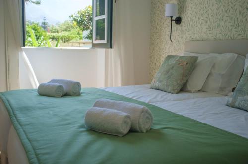 ein Schlafzimmer mit zwei Betten mit Handtüchern darauf in der Unterkunft Casa Oliveira Esmeraldo - Guest Houses in São Vicente