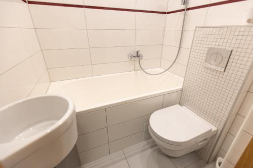 Baño blanco con aseo y lavamanos en City center Gauja apartment, en Valmiera