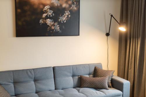 a blue couch in a living room with a lamp at City center Gauja apartment in Valmiera