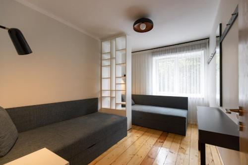 a living room with a couch and a window at City center Gauja apartment in Valmiera