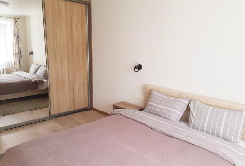 ein Schlafzimmer mit einem großen Spiegel und einem Bett in der Unterkunft Apartamentai Vilniaus Street II in Šiauliai