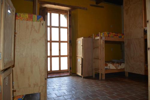 a room with two bunk beds and a window at Rossco Hostel & Hotel in San Cristóbal de Las Casas