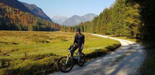 a man riding a bike on a dirt road at Zajček Apartma in Mojstrana