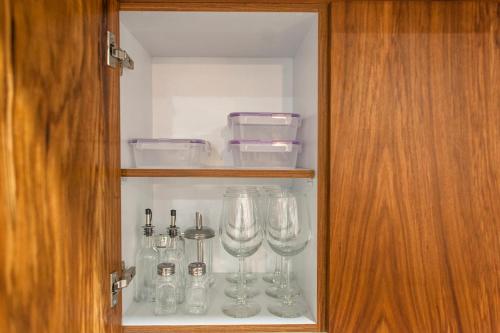 a glass cabinet with wine glasses in it at Gulliver condo - Free beach club access & Bikes in Tulum