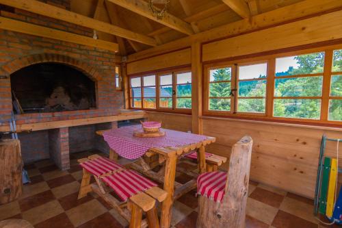 a dining room with a table and a fireplace at Mountain house Popović Tara in Bajina Bašta