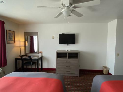 a bedroom with a bed and a flat screen tv at Guest House Inn Medical District near Texas Tech Univ in Lubbock