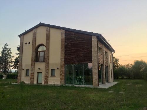 una antigua casa de ladrillo con una gran ventana en Agriturismo LaTerzola 3.0, en Fiorenzuola dʼArda