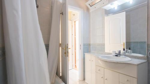 a white bathroom with a sink and a mirror at La Finca in Chayofa