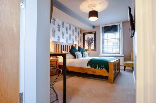 a bedroom with a bed and a desk in a room at The Wheatsheaf Pub, Kitchen & Rooms in Bingham