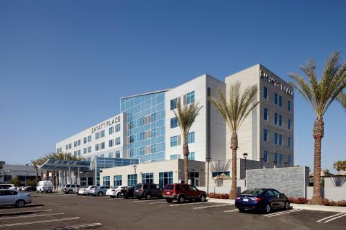 un parking avec des voitures garées devant un grand bâtiment dans l'établissement Hyatt Place Bakersfield, à Bakersfield