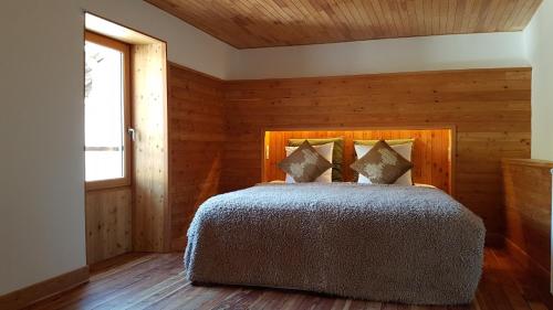 A bed or beds in a room at Auberge du Bachelard