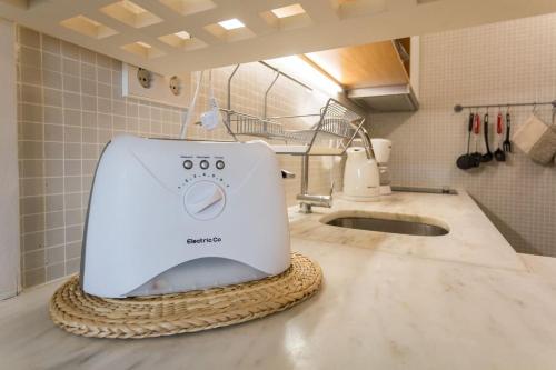 Una tostadora blanca sentada en una encimera en una cocina en 1Bed Apart Quinta do Lago, en Almancil
