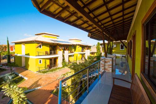 uma varanda de uma casa com um edifício amarelo em Vila Miola Hotel em Porto Seguro